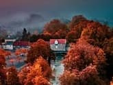 Aerial view of a Masonic lodge building surrounded by autumn trees with vibrant red and orange foliage